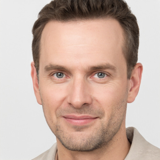 Joyful white adult male with short  brown hair and grey eyes