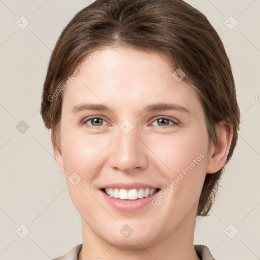 Joyful white young-adult female with medium  brown hair and grey eyes