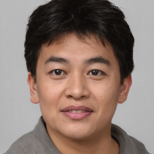 Joyful asian young-adult male with short  brown hair and brown eyes