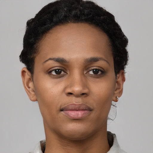Joyful black young-adult female with short  black hair and brown eyes