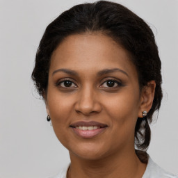 Joyful black adult female with medium  brown hair and brown eyes