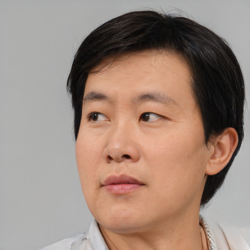 Neutral asian adult male with medium  brown hair and brown eyes