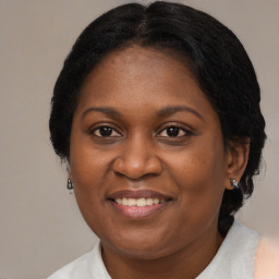 Joyful black adult female with medium  brown hair and brown eyes