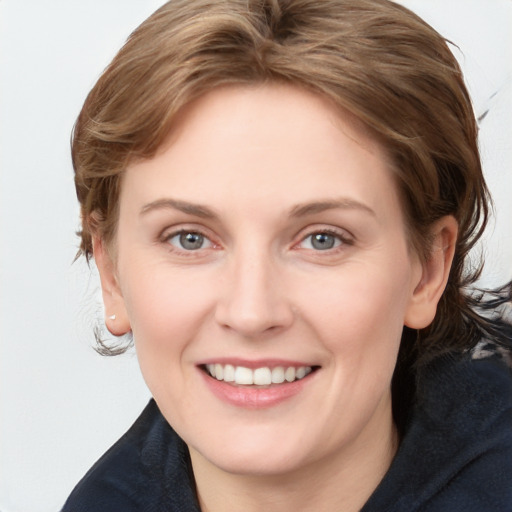 Joyful white young-adult female with medium  brown hair and grey eyes