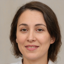 Joyful white adult female with medium  brown hair and brown eyes