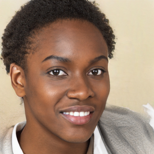 Joyful black young-adult female with short  brown hair and brown eyes