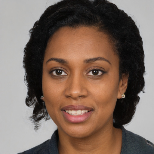 Joyful black young-adult female with medium  black hair and brown eyes