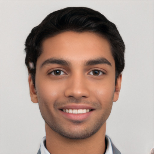 Joyful latino young-adult male with short  black hair and brown eyes