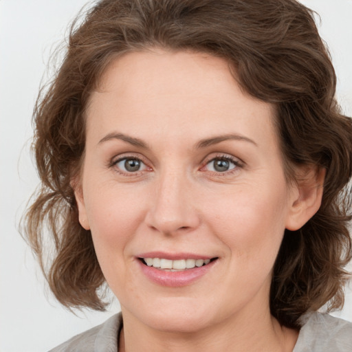 Joyful white adult female with medium  brown hair and grey eyes