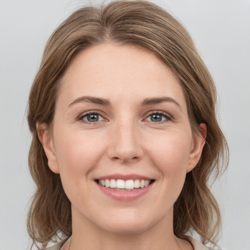 Joyful white young-adult female with medium  brown hair and grey eyes