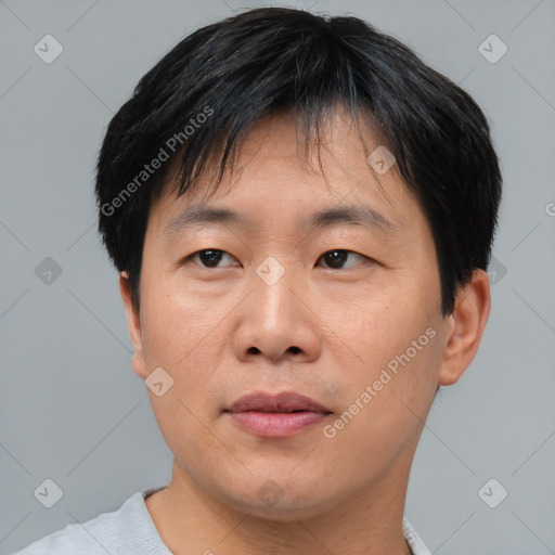 Joyful asian adult male with short  black hair and brown eyes