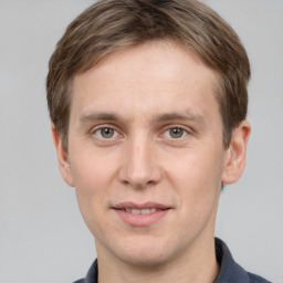 Joyful white young-adult male with short  brown hair and grey eyes