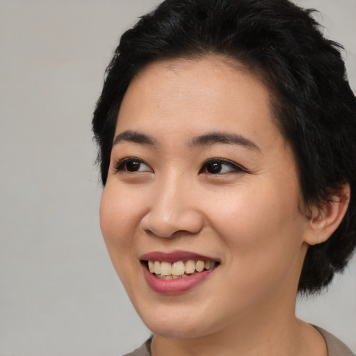 Joyful asian young-adult female with short  black hair and brown eyes