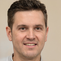 Joyful white adult male with short  brown hair and grey eyes