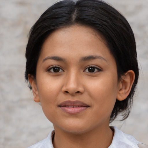 Joyful latino young-adult female with medium  brown hair and brown eyes