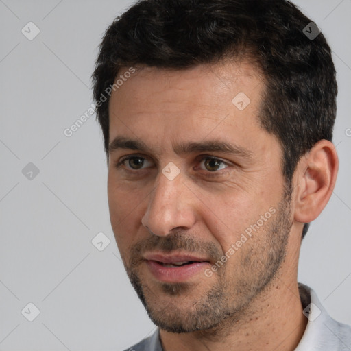 Joyful white adult male with short  black hair and brown eyes