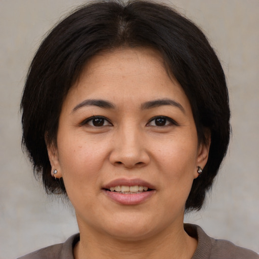 Joyful asian adult female with medium  brown hair and brown eyes