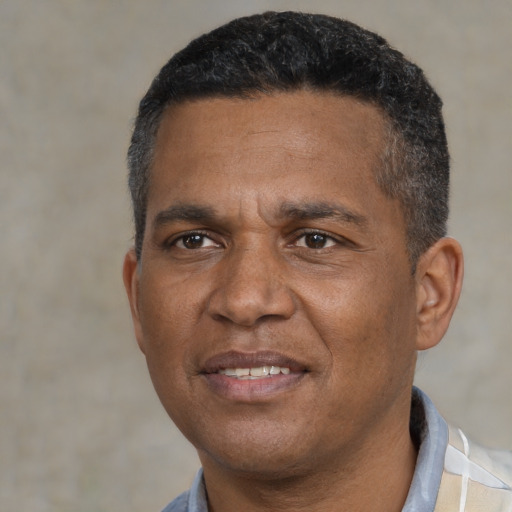 Joyful black adult male with short  black hair and brown eyes
