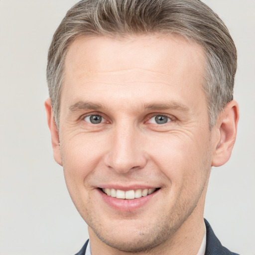 Joyful white adult male with short  brown hair and grey eyes