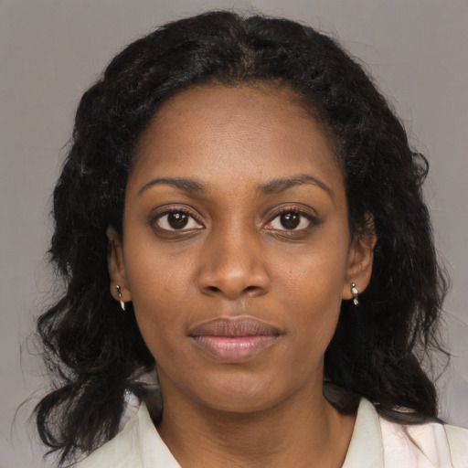Joyful black young-adult female with long  black hair and brown eyes