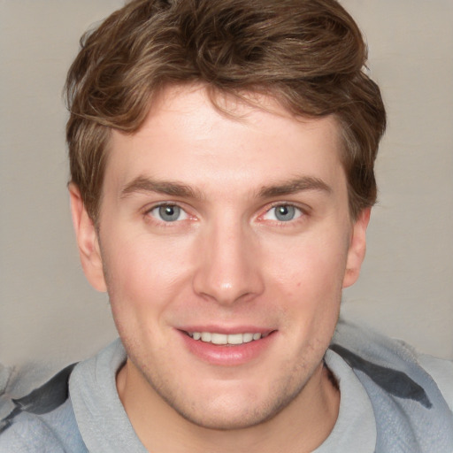 Joyful white young-adult male with short  brown hair and blue eyes