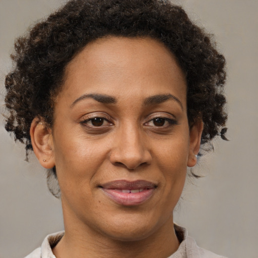 Joyful black adult female with short  brown hair and brown eyes