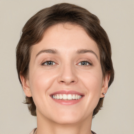 Joyful white young-adult female with medium  brown hair and green eyes