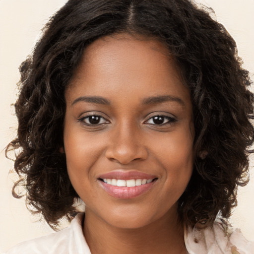 Joyful black young-adult female with long  brown hair and brown eyes