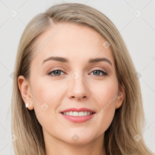 Joyful white young-adult female with long  brown hair and blue eyes