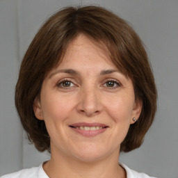 Joyful white adult female with medium  brown hair and brown eyes