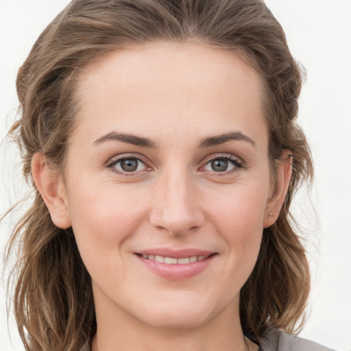 Joyful white young-adult female with medium  brown hair and grey eyes