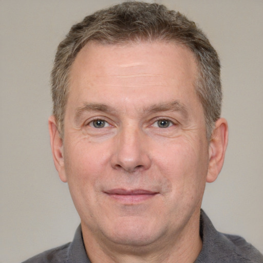 Joyful white adult male with short  brown hair and grey eyes