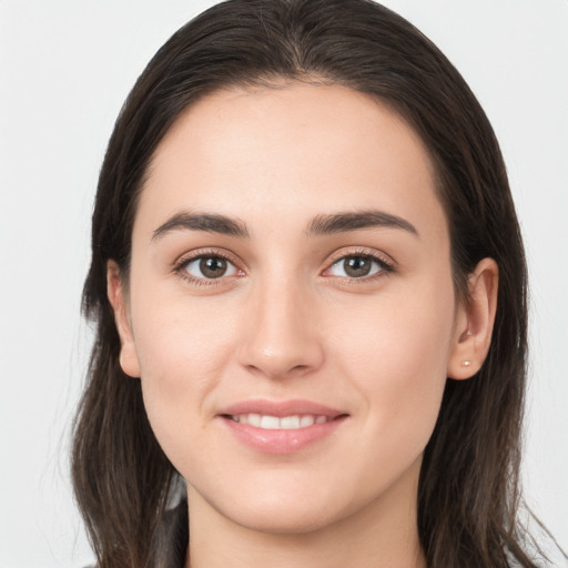 Joyful white young-adult female with long  brown hair and brown eyes