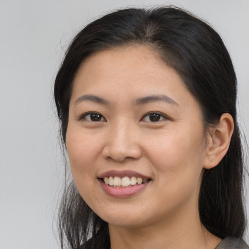 Joyful asian young-adult female with long  brown hair and brown eyes