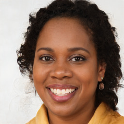 Joyful black young-adult female with long  brown hair and brown eyes