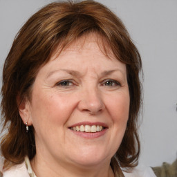 Joyful white adult female with medium  brown hair and blue eyes