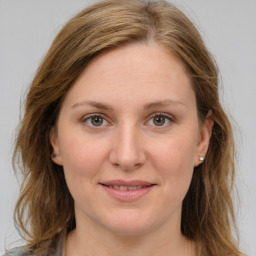 Joyful white young-adult female with long  brown hair and green eyes