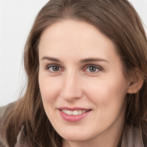 Joyful white young-adult female with long  brown hair and grey eyes