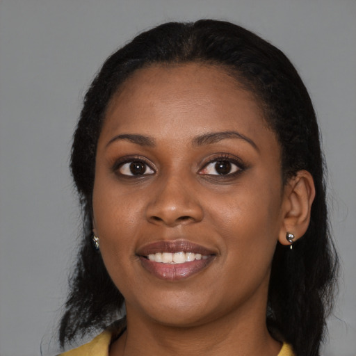 Joyful black young-adult female with long  black hair and brown eyes