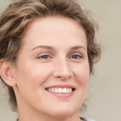 Joyful white young-adult female with medium  brown hair and blue eyes