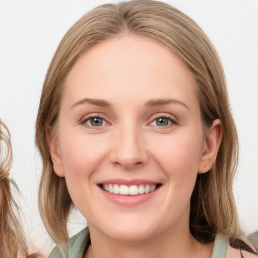 Joyful white young-adult female with medium  brown hair and blue eyes