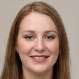 Joyful white young-adult female with long  brown hair and green eyes