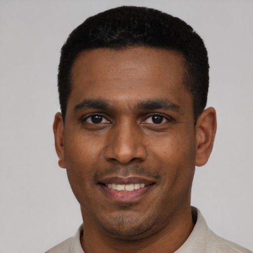 Joyful black young-adult male with short  black hair and brown eyes