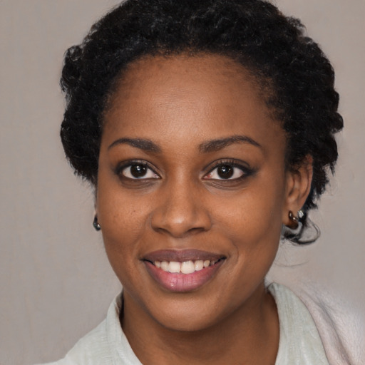 Joyful black young-adult female with short  brown hair and brown eyes