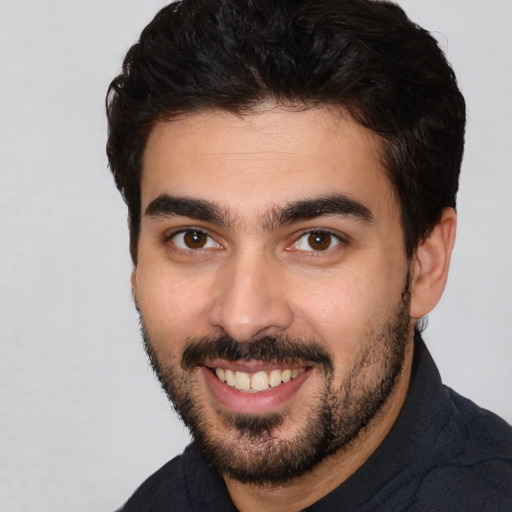 Joyful white young-adult male with short  black hair and brown eyes