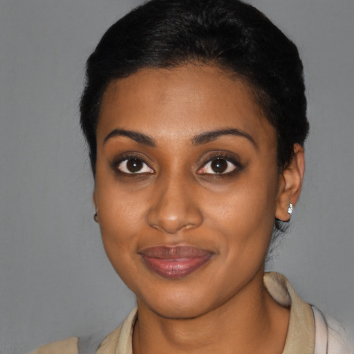 Joyful black young-adult female with medium  black hair and brown eyes