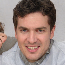 Joyful white adult male with short  brown hair and brown eyes