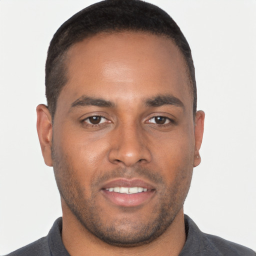Joyful black young-adult male with short  brown hair and brown eyes