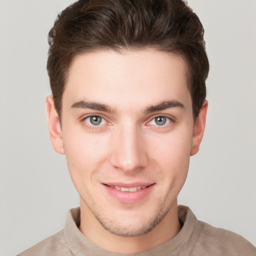 Joyful white young-adult male with short  brown hair and grey eyes