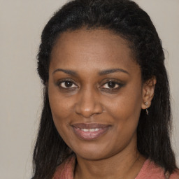 Joyful black young-adult female with long  brown hair and brown eyes